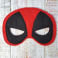 a close up of a mask on a white wooden surface with wood planks in the background