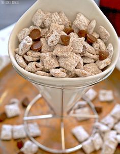 a white bowl filled with dog food on top of a metal stand next to a wooden table