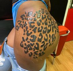 a woman with a tattoo on her back has a large leopard print on it's side