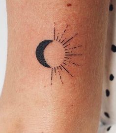 a small sun and moon tattoo on the ankle, with black dots around it's edges