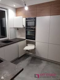 an empty kitchen with white cabinets and black counter tops is seen in this image, there are no people around