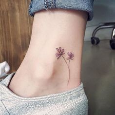 a small flower tattoo on the ankle