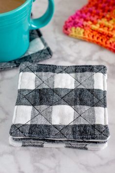 a cup of coffee sitting on top of a table next to two napkins and a mug