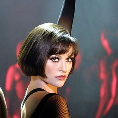 a woman with short hair wearing a black dress and cat ears on top of her head