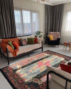 a living room with two couches and a rug in front of the window on the floor