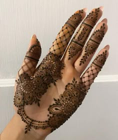 a hand with henna on it that has intricate designs and lines in the middle