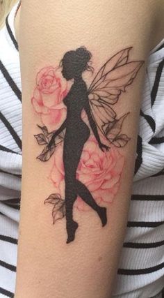 a woman's arm with a flower and fairy silhouette tattoo on the left side