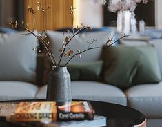 a living room filled with furniture and a vase on top of a table in front of a couch