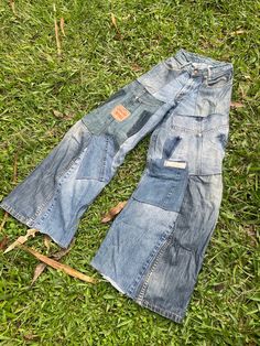 an old pair of jean pants laying on the grass with one patched off and another patched off