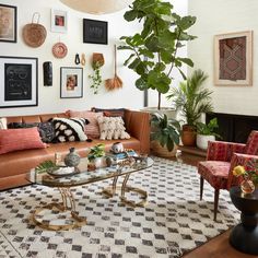 a living room filled with lots of furniture next to a fire place and potted plants