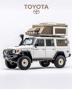 a white toyota truck with a camper attached to it's roof and the words toyota above it