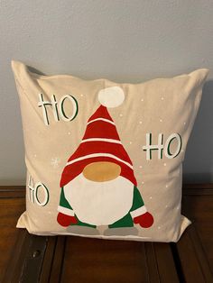 a pillow with an image of a santa clause on it, sitting on a wooden table