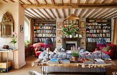 a living room filled with lots of furniture and bookshelves covered in bookcases