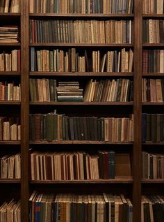 a bookshelf filled with lots of books on top of wooden shelves