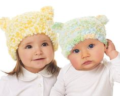 two young children wearing knitted hats on their heads