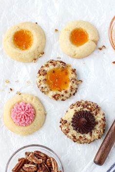 some cookies and nuts are sitting on the table next to each other, including one with an egg in it