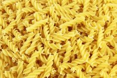 closeup of yellow pasta textured with water droplets on the top, and bottom