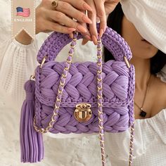 a woman holding a purple handbag in her hands