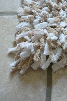 a pile of toilet paper sitting on top of a tile floor next to a brush