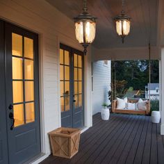 a porch with two lights and a bench on the front deck area next to it