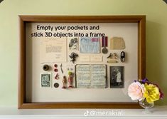 a wooden frame with some pictures on it and flowers in a vase next to it