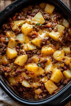 a casserole dish with potatoes and ground beef in it on a wooden table