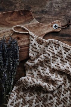 a knitted dishcloth next to dried lavender on a cutting board with a wooden spoon