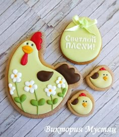 decorated cookies are sitting on a table with flowers and eggs in the shape of chickens