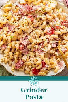 a white plate topped with pasta salad next to a yellow fork and green sign that says grinder pasta