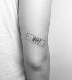 a black and white photo of a person with a band aid tattoo on their arm