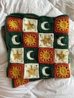 a crocheted blanket with sun and moon on it