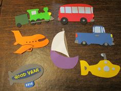 paper cut out of different types of cars and trucks on a wooden table with the words good year written below