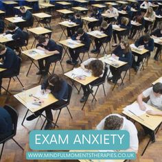 an exam room filled with students sitting at desks and writing on their notebooks