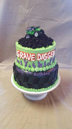 a birthday cake made to look like a grave digger truck on top of a pile of dirt