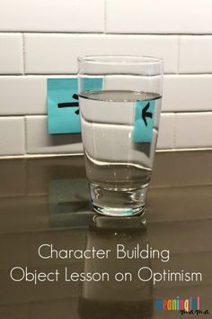 a glass filled with water sitting on top of a counter next to a blue marker