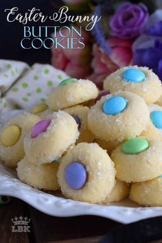 easter bunny button cookies on a plate with flowers in the background and text overlay