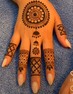 a woman's hand with henna tattoos on it