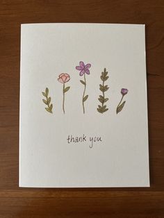 a thank card with three flowers and the words thank you written in purple on it