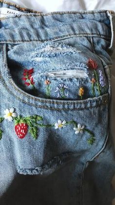 a pair of jeans with embroidered flowers on them