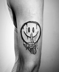 a black and white photo of a man's arm with a smiley face drawn on it