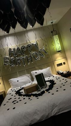 a bedroom decorated with balloons and streamers for a happy birthday message on the wall