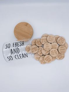 a jar filled with lots of wooden buttons next to a bottle full of wood discs