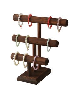 a wooden rack with several bracelets hanging from it's sides and two rings on each end