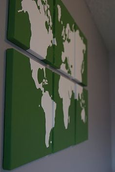 two green and white wall art pieces with the world map painted on each one piece