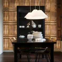 a dining room table with white plates and bowls on it in front of a bookshelf