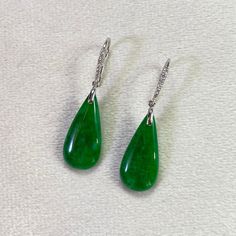 These exquisite teardrop jade earrings feature an 18k white gold setting adorned with scattered diamonds, adding a touch of brilliance. The beautiful combination of the rare jade gemstone and the sparkling diamonds creates a captivating and luxurious design that enhances any outfit. Material: 18k White Gold Gemstone: Natural untreated Type A Burmese Jadeite; Genuine round diamond Jadeite color: Intense Green Total length: 36.2 mm Jade width: 22.2 mm Jade Width 9.9 mm The benefits of natural jade Teardrop Jade Earrings For Formal Occasions, Elegant Jade Teardrop Earrings, Elegant Teardrop Jade Earrings, Elegant Green Hypoallergenic Teardrop Earrings, Elegant Jade Drop Jewelry, Elegant Teardrop Jade Jewelry, Elegant Green Teardrop Pendant Earrings, Green Pear-shaped Teardrop Earrings For Formal Occasions, Cleansing Stones