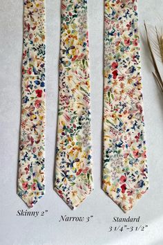 three ties with different designs on them sitting next to each other and one is taller than the other