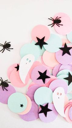 paper cut outs with black stars and ghost faces on them, all in pastel colors