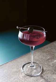 a close up of a wine glass with a drink in it on a counter top