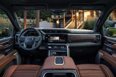 the interior of a vehicle with brown leather seats and dashboards, along with stairs leading up to a building